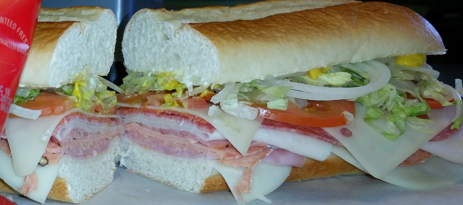 Close-up of a Tony's sub with deli meats, cheese, tomato, lettuce and onion