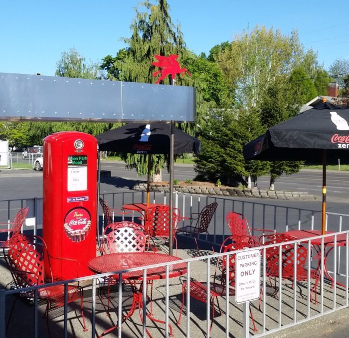 Outdoor patio tables next to a red vintage gas pump at Tony's